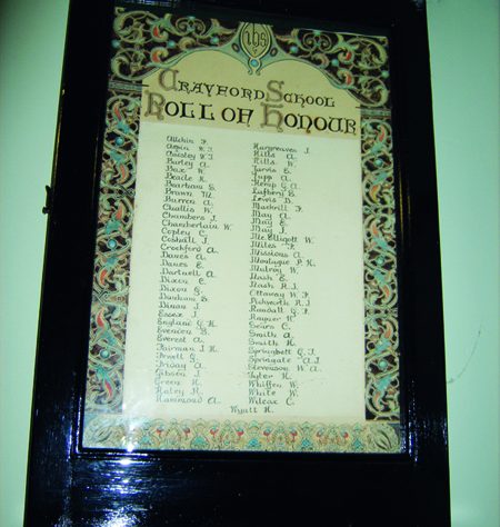 GE DIGITAL CAMERA Crayford School roll of honour. The board lists names.