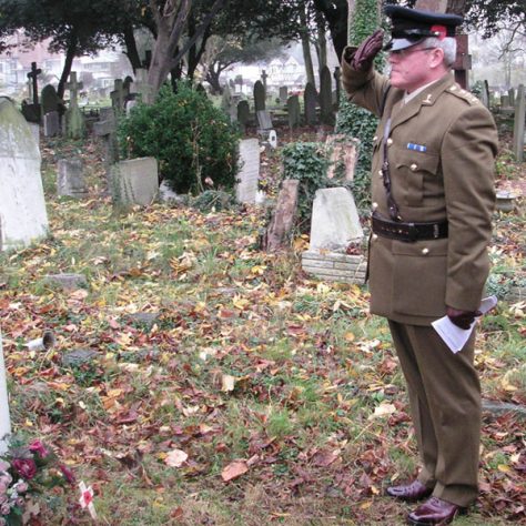 Friday11November-12 A salute for the fallen. A man in soldier's uniform salutes a grave.