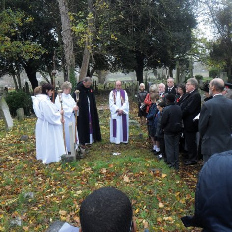Friday11November-15 Remembrance gathering. People in a graveyard solemnly praying.