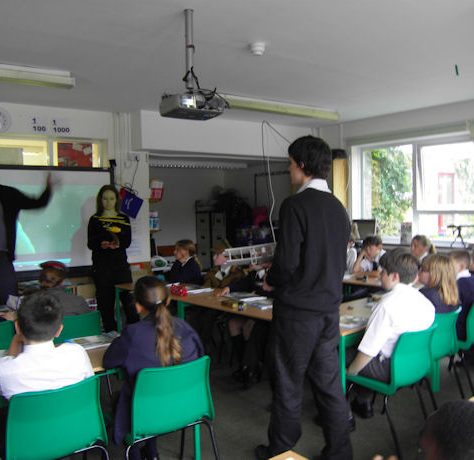 St-paulinus-8 St Paulinus, Greenwich. A teacher takes a class, assisted by a large monitor screen.