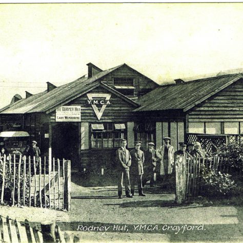 Rodney Hut, YMCA Crayford, c. 1916. Some men stand outside the large wooden structure. A car can be seen to the side of the hut.