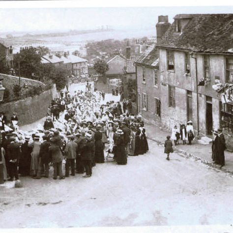 parade111 A crowd of people gather in the street for a parade.